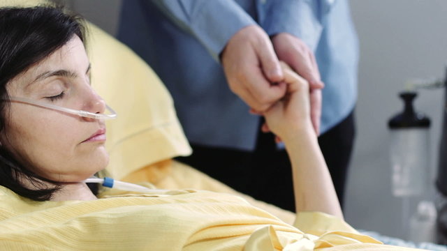 man does caresses and holds the hand to his wife in hospital