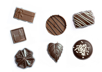 Différents bonbons en chocolat sur fond blanc