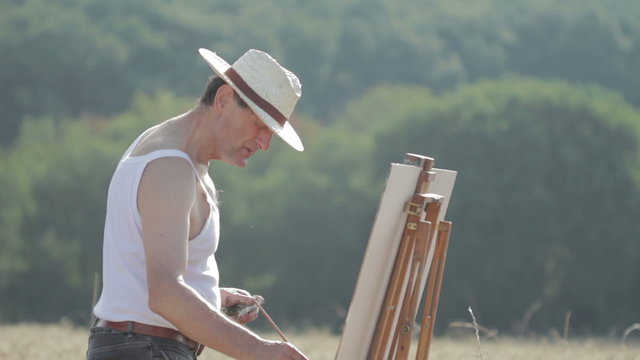 painter in the middle of a wheat field paints a beautiful landscape, canvas