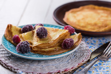 Pancakes or crepes with berries on plate  . Selective focus.