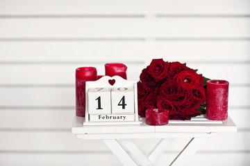 Fototapeta premium red roses lay on the table near calendar with the date of Febru