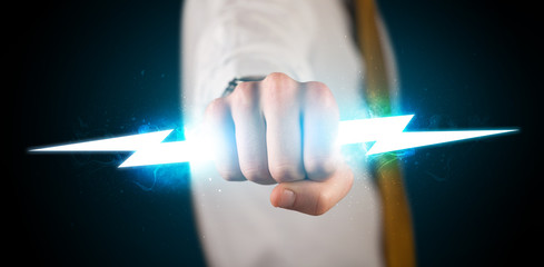 Business man holding glowing lightning bolt in his hands