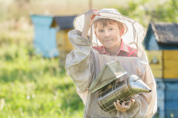 Teenage beekeeper using a smoker on bee yard