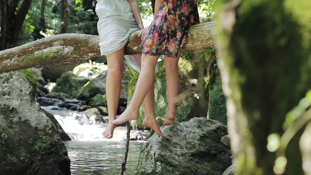 live in harmony with the nature - legs dangling from a tree near a stream