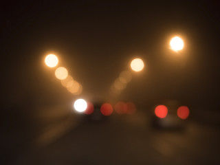 blurred lights of cars on the road in the fog