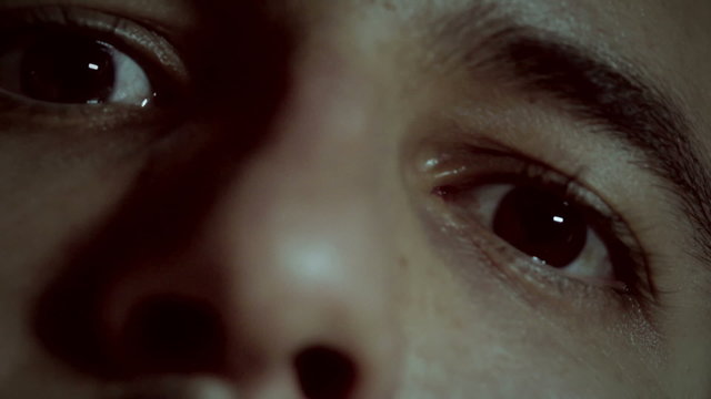 close up of an insane man who smokes and spits the smoke from his nose - madman