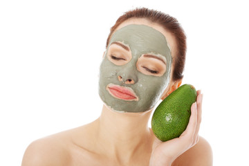 Beautiful spa woman in facial mask and avocado