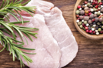 Pork chop, meat slices  on a wood background.