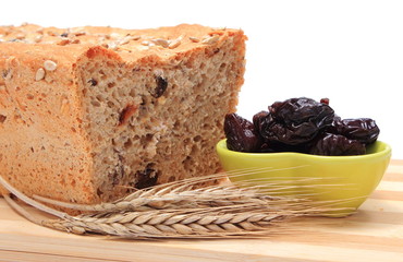 Baked wholemeal bread, dried plums and ears of wheat