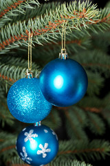 Three christmas balls on a tree.