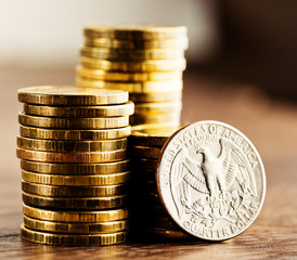 us quarter dollar coin and gold money on the desk