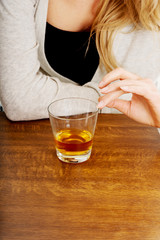 Yound woman in depression, drinking alcohol
