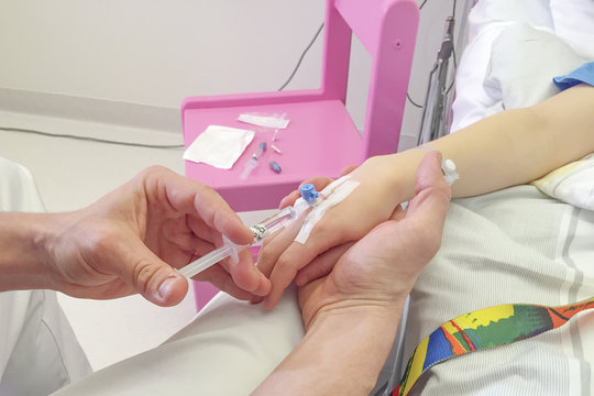 Young boy getting glucose injection in vain