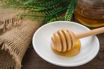 Honey dipper on plate and jar
