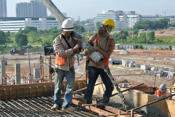 Construction Workers casting concrete using concrete hose