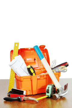 Plastic toolbox with various working tools stands on a table