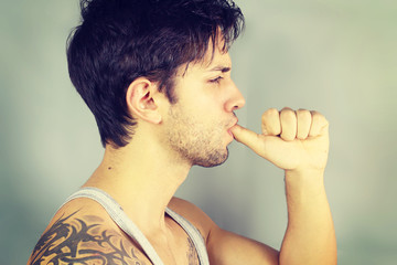 Portrait of a handsome man sucking his thumb