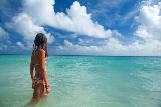 Girl enjoys summer day at the tropical beach.