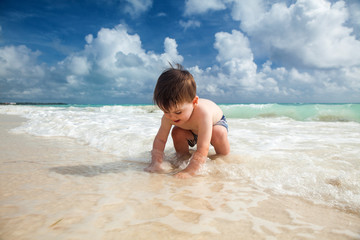 Fototapeta na wymiar Boy enyojs summer day at the tropical beach.
