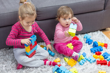 Little Girl and Baby Playing Together