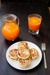 Delicious homemade cheese pancakes with fresh carrot juice
