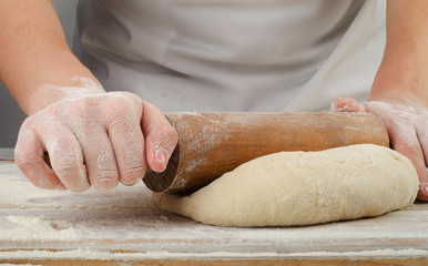 Fototapeta premium Woman preparing dough on wooden table.