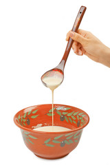 The batter for pancakes in traditional ceramic bowl