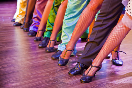 dancer legs on stage in dance position, male female colorful