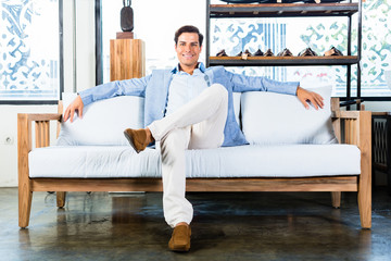 Man sitting on couch in furniture store showroom