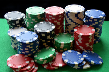 Red, blue, green, white and black poker chips pile