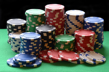 Red, blue, green, white and black poker chips pile