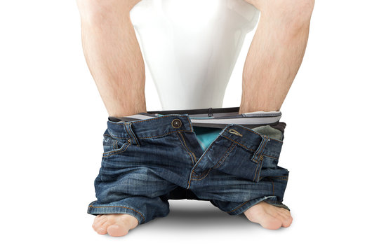 Man sitting on a toilet seat with his pants and boxers down