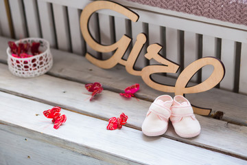 Sweet fancy and colorful baby shoes on the wooden desk with girl