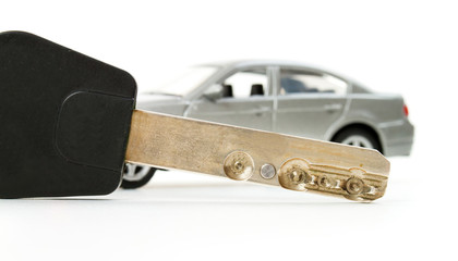 Key and little toy car in blur isolated on white background