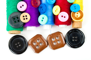 color buttons and thread bobbins on the white background