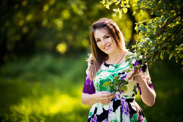 Beautiful pregnant woman in sunny park