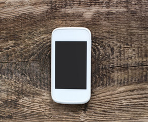 White smart phone with isolated screen on old wooden desk.