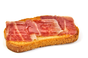Spanish serrano ham on bread slice. White background. Tapa.