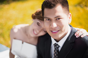 the bride and groom sit in the park and petting