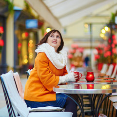 Happy girl drinking coffee in a Parisian cafe