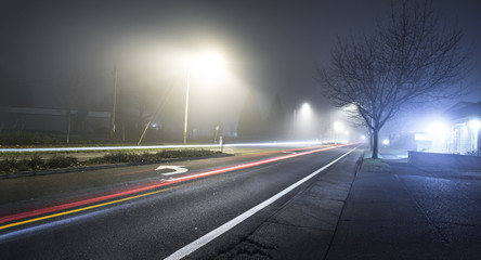 Road at night with fog and long exposure of car trail