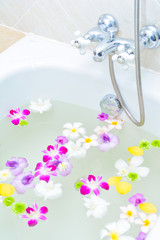 flower and mineral water in bathtub
