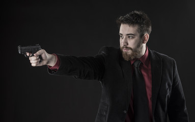 Young Man in Black Suit Aiming a Gun