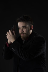 Goatee Man in Black Suit Holding Weapon