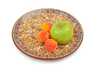 Bowl of oatmeall with fruit on a plate, isolated on white..