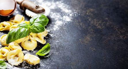 Homemade raw Italian tortellini and basil leaves