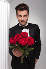 business man giving you a bouquet of red roses