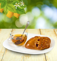 cup of tea and buns on a table on a green background