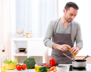 Young attractive man cooking in a kitchen