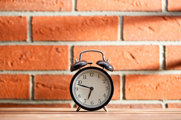 old clock in front of a brick wall